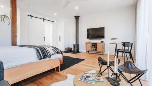 a bedroom with a bed and a tv on a wall at Morradoo Studio in Flinders