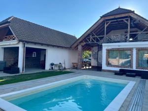 a house with a swimming pool in the yard at Villa Maximilian in Balatonkeresztúr