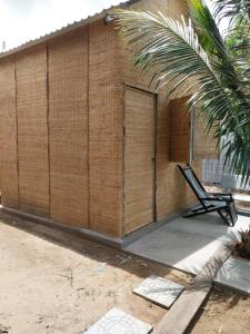 - un bâtiment avec une porte et une chaise devant dans l'établissement BenTrestay, à Giồng Tú Ðiền