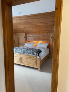 una camera da letto con un letto con una parete in legno di Haus Hochland - Großzügige Alpenwohnung im Dachgeschoss a Bad Kohlgrub