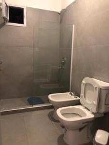 a bathroom with a toilet and a shower stall at Copacabana’s House Microcentro in Salta