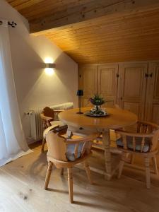 ein Esszimmer mit einem Holztisch und Stühlen in der Unterkunft Großzügige Alpenwohnung im Dachgeschoss in Bad Kohlgrub