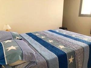 a bedroom with a bed with a blue and white blanket at Copacabana’s House Microcentro in Salta