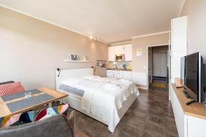 a bedroom with a bed and a table and a tv at Hafenperle in Schilksee
