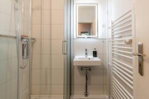 a small bathroom with a sink and a shower at Hafenperle in Schilksee