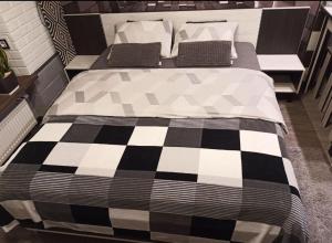 ein Bett mit einer schwarz-weißen karierten Decke in der Unterkunft Wiew Lux Studio Apartments in a Secure Residential Complex Comfort Town КТ-03 in Kiew