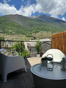 balcón con mesa, sillas y montañas en DUPLEX con VISTA e TERRAZZA [6 minuti dal Bernina Express], en Tirano