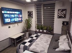 a room with a bed and a tv and plants at Wiew Lux Studio Apartments in a Secure Residential Complex Comfort Town КТ-03 in Kyiv