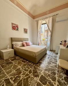 um quarto com uma cama e uma grande janela em Casa MiRè em Catânia
