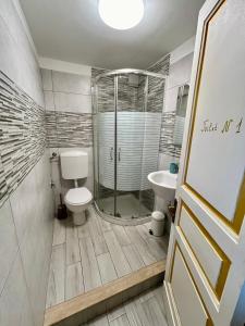 uma casa de banho com um chuveiro, um WC e um lavatório. em Casa MiRè em Catânia