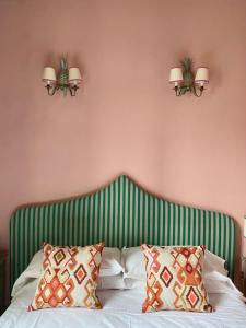 a bedroom with a bed with green and white stripes at Hotel Hermitage in Florence