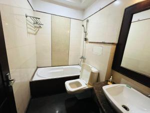 a bathroom with a toilet and a sink and a tub at Hotel Imperial Inn - Nehru Enclave in New Delhi