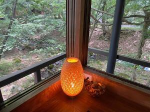 an orange lamp sitting on a window sill in front of a window at Tabinoteitaku Zao Miyagi in Zao
