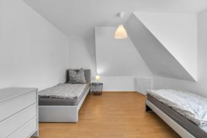 um quarto com 2 camas e uma parede branca em Nützlich und zentrale Kurzzeitwohnung - Unna DG em Unna