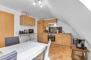 una cocina con armarios de madera y una mesa blanca en una habitación en Nützlich und zentrale Kurzzeitwohnung - Unna DG en Unna