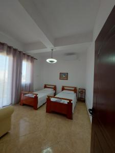 Cette chambre comprend 2 lits et un canapé. dans l'établissement Guest House Irvin, à Berat