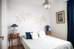 Un dormitorio con una cama blanca con almohadas azules y blancas en Belle maison lumineuse et paisible en Reims