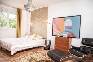 a bedroom with a bed and a tv on a wall at Belle maison lumineuse et paisible in Reims