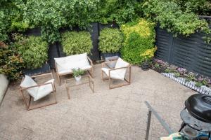 漢斯的住宿－Belle maison lumineuse et paisible，一个带椅子和植物的庭院和围栏
