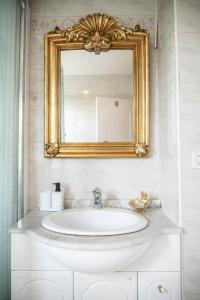 y baño con lavabo y espejo de oro. en Belle maison lumineuse et paisible en Reims