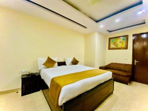 a bedroom with a large bed and a couch at Hotel Imperial Inn - Nehru Enclave in New Delhi
