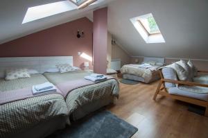 a attic bedroom with two beds and two windows at La Casa de Maria in Santillana del Mar