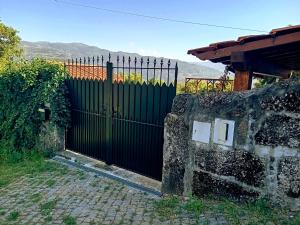 una puerta negra frente a una pared de piedra en A casa do Pastorinho en Baião