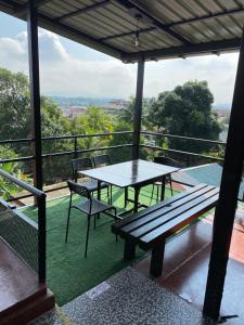 uma mesa de piquenique e cadeiras numa varanda com vista em Igo homestay - Family Room em Shah Alam