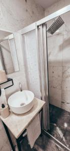 a bathroom with a white sink and a shower at La Luna Otel Cunda in Ayvalık