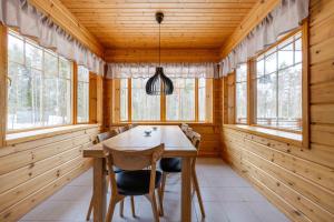 a dining room with wooden walls and a wooden table and chairs at Lomamökki Himos Taivaanranta in Jämsä