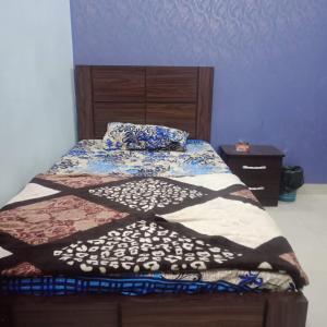 卡拉奇的住宿－HostHub Guest House Gulshan iqbal，一间卧室配有一张带木制床头板的床