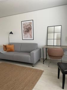a living room with a gray couch and a table at Saunallinen kaksio 5 in Ylivieska