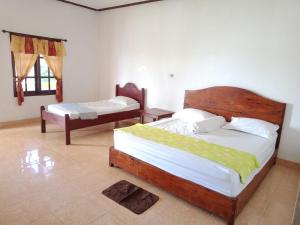 A bed or beds in a room at Harus Damai Inn