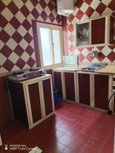 a kitchen with pink and white checkered walls at فندق وشقق ليالي الاحلام للشقق المخدومه in Baljurashi