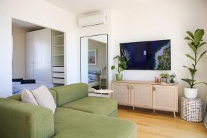 a living room with a green couch and a mirror at Kiki's Sea View Studio's in Split
