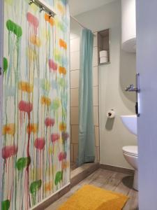 a bathroom with a shower with a colorful shower curtain at Apartment Kuca Merdzo in Orebić