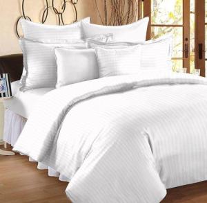 ein weißes Bett mit weißer Bettwäsche und Kissen in der Unterkunft HOTEL NEW BADRINATH in Badrīnāth