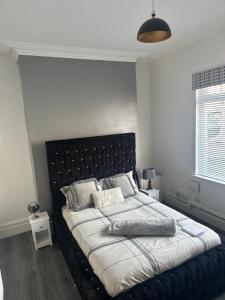 a bed with a black headboard in a bedroom at Sheriff suites in Hartlepool