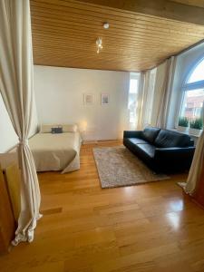 uma sala de estar com um sofá e uma cama em Altbauwohnung mit 2 Balkonen em Wuppertal