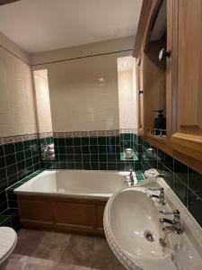 La salle de bains est pourvue d'une baignoire, d'un lavabo et de toilettes. dans l'établissement Rare & exclusive country cottage, à Hurn