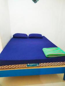 Una cama con un colchón azul y un bolígrafo. en WISMA TIGA PUTRA BELAWA 2 en Topoyo