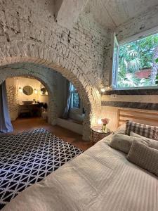 1 dormitorio con 1 cama grande y pared de piedra en Dependance in giardino storico - Oltrarno, en Florencia