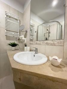 bagno con lavandino bianco e specchio di Gertrudy 10 Residence a Cracovia