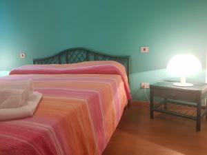 a bedroom with a bed and a table with a lamp at Sa Jaga Brujada Residence - Simar Vacanze in Porto Rotondo