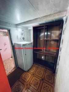 um quarto vazio com um frigorífico e um piso em Konkan Central Kankavali - Budget Home Stay em Kankauli