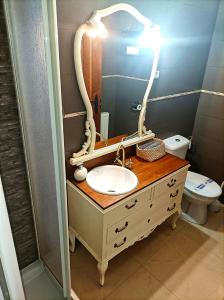 La salle de bains est pourvue d'un lavabo, d'un miroir et de toilettes. dans l'établissement El Rincon De Luna, à Moratilla de los Meleros