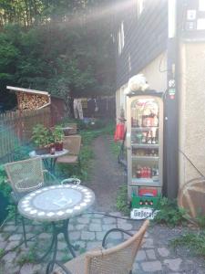 an outdoor patio with a table and a refrigerator at Zum stillen Himmelbett in Niederwiesa