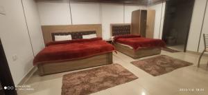 two beds in a room with two rugs at Dhanolti Resort in Dhanaulti
