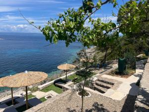 Blick auf das Meer von einem Resort mit Sonnenschirmen in der Unterkunft Paxos Sunrise Villas in Gaios