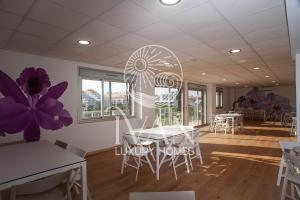 ein Esszimmer mit weißen Tischen, Stühlen und lila Blumen in der Unterkunft Casa Andrea Ivan Luxury Homes 4ªPlta Sur 1ªLínea in Oropesa del Mar